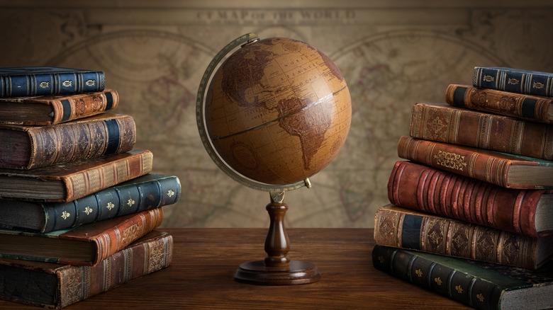 Globe standing in the middle of stacks of books