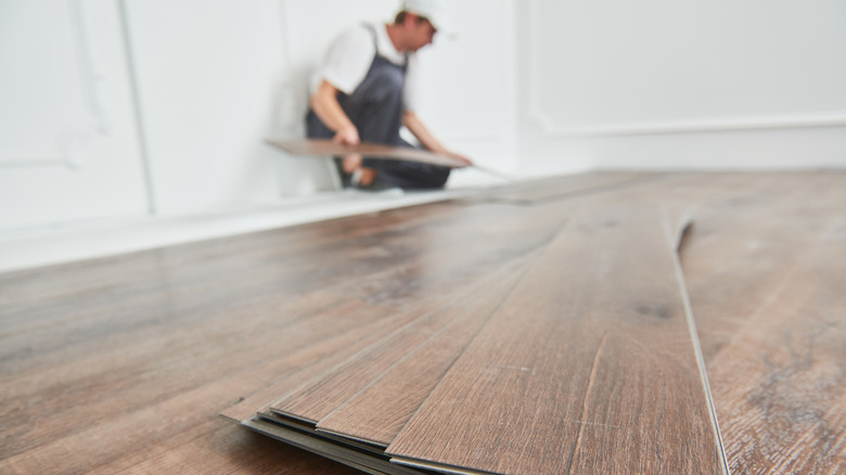 person installing vinyl plank flooring