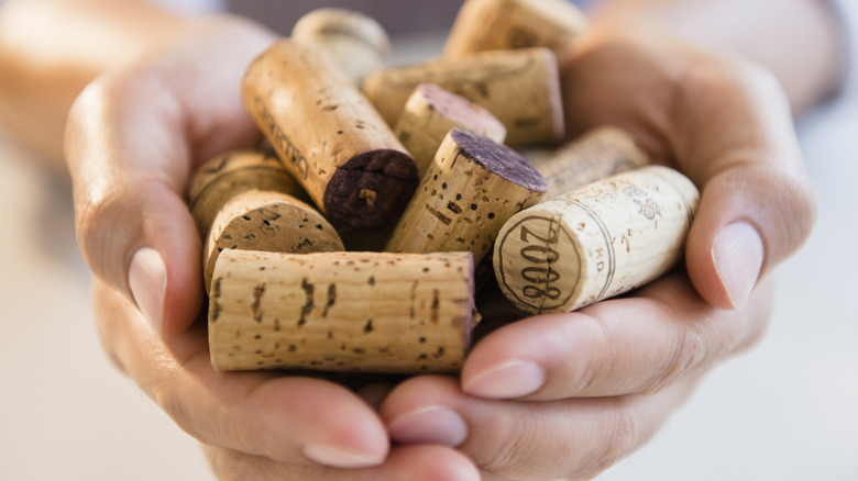 Someone holding several wine corks