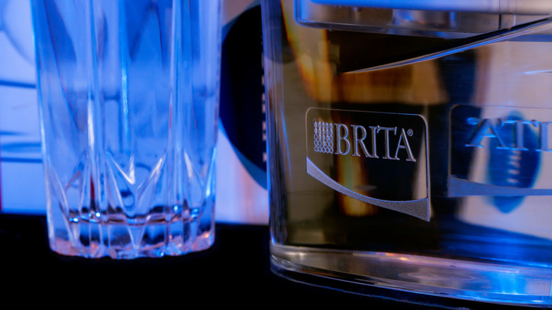 Brita water filter pitcher beside glass of water