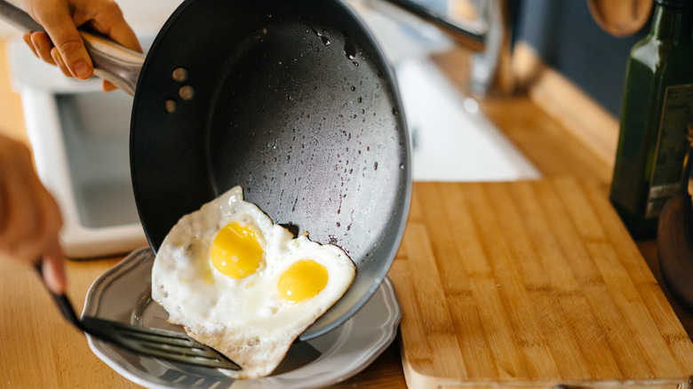 fried eggs sliding out of a nonstick pan