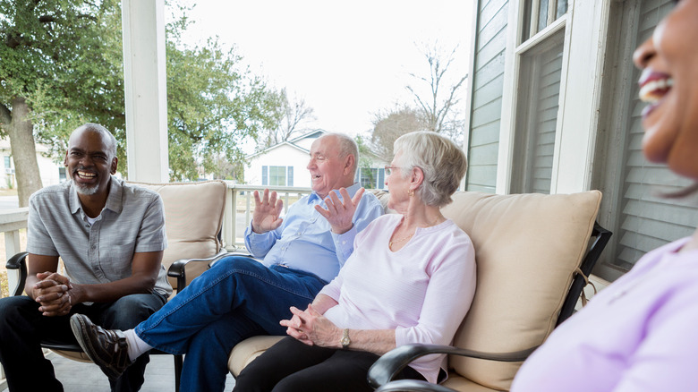 Four neighbors chatting on porch