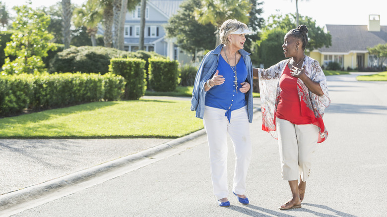 Two neighbors walking down street 
