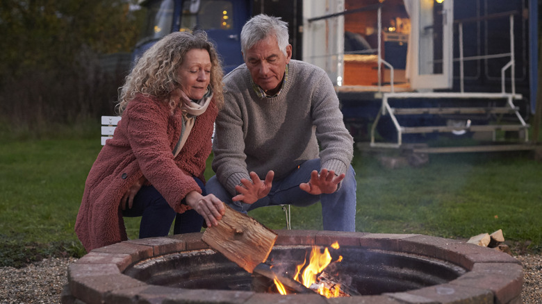 A man and woman enjoying a fire pit in the backyard