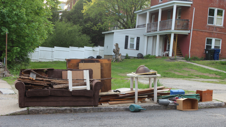 Old furniture and household junk on the curb.