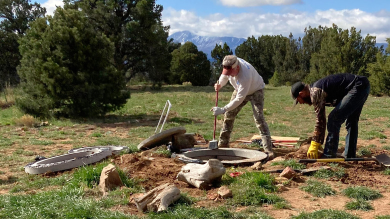 Two men working on a septic system