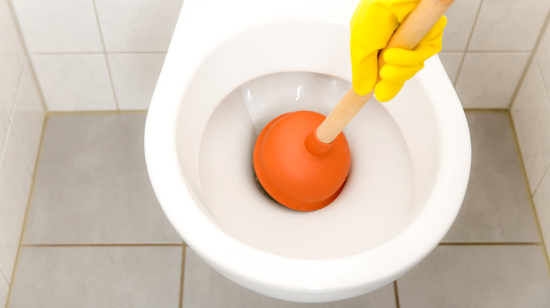 using plunger to unclog toilet