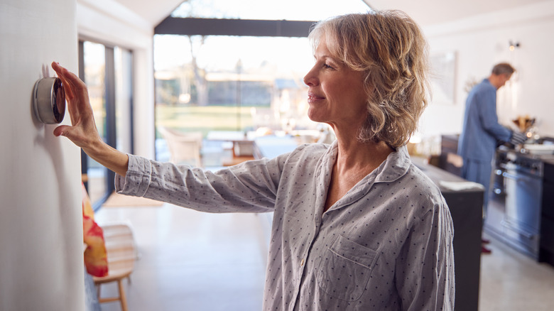 woman changing thermostat