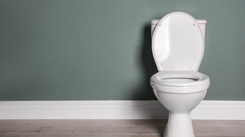 White toilet on grey wall