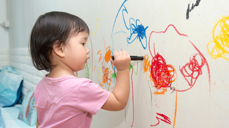 child drawing on wall