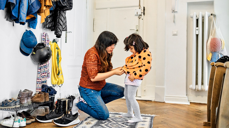 woman zipping child's coat