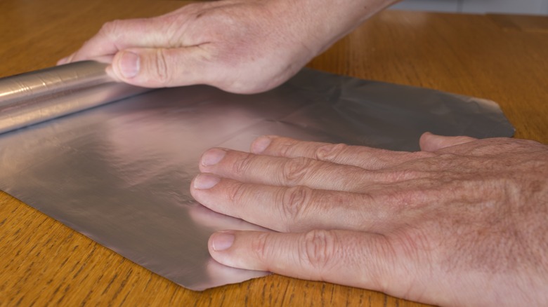 Someone tearing off aluminum foil