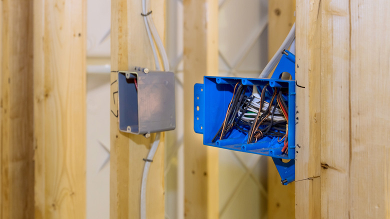 Two types of plastic electrical boxs installed on wall studs