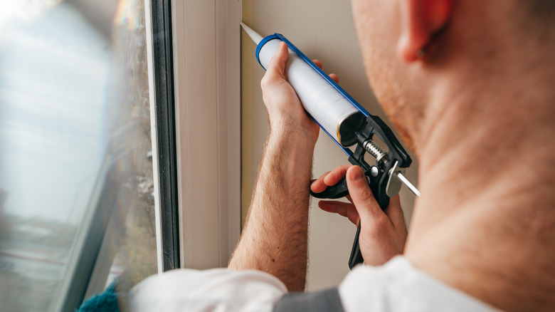 person using caulk gun