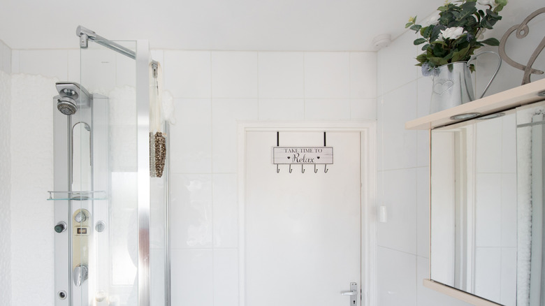 A metal and wood coat rack over a bathroom door