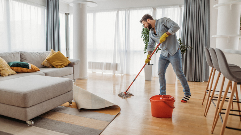 man mopping apartment