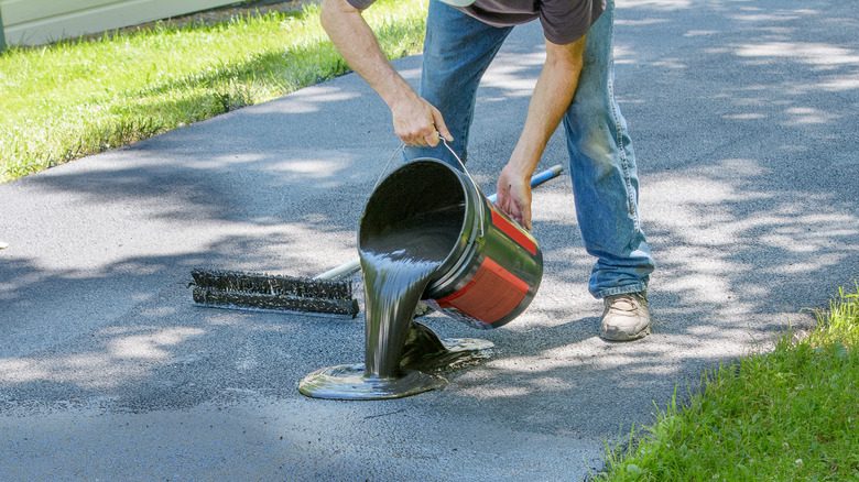 pouring sealer on driveway
