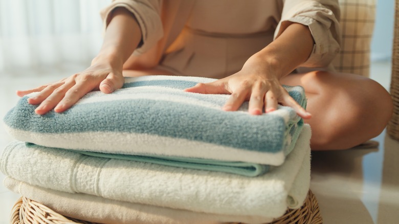 Woman's hands on stack of clean towels