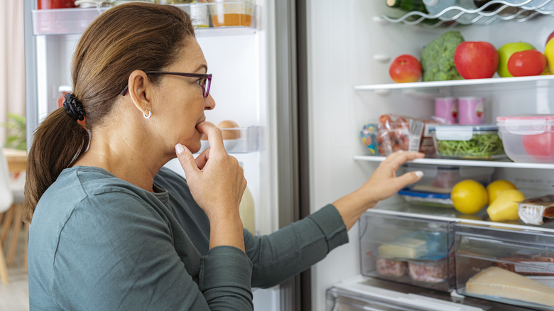 Woman looking in refrigerator