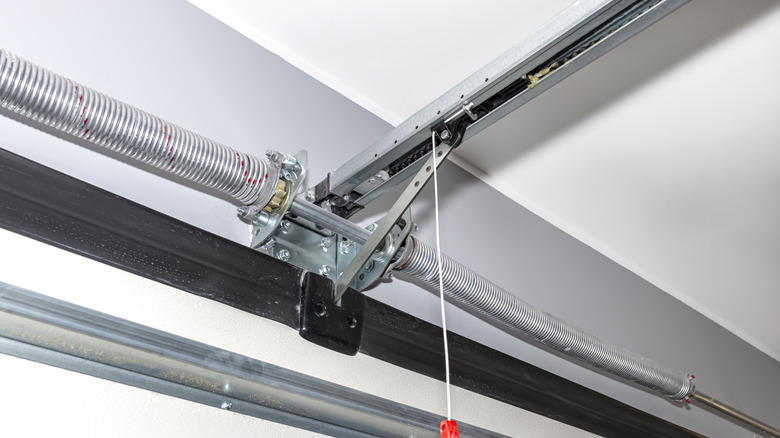 Close-up view of a garage door torsion spring and metal support assembly