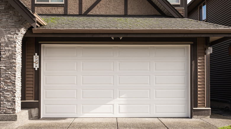White garage door on a modern suburban house with stone and wood accents