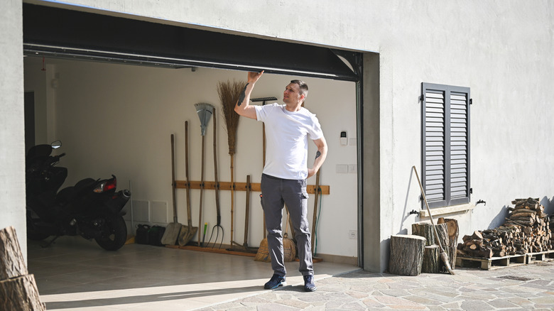 A man looking at an open garage door