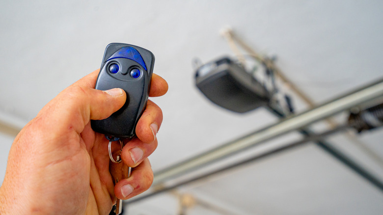 Person holding a garage door remote in their hand