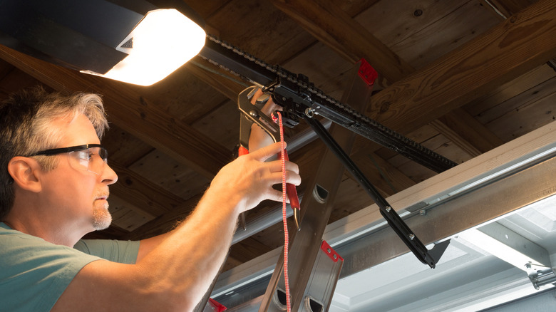 A professional fixing a garage door opener