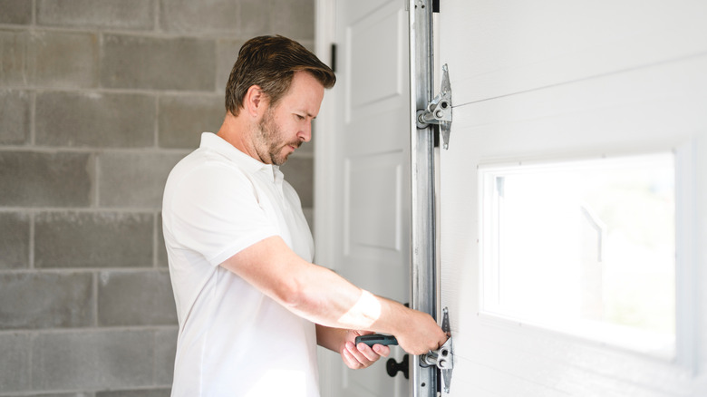A man fixing a garage door