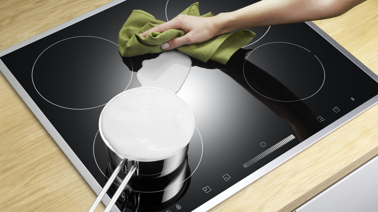 Hand cleaning mess off of stove top