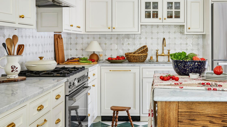 Traditional-style modern kitchen with white cabinets and polished brass hardware.