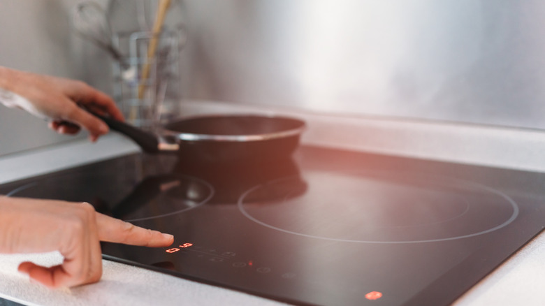 person cooking on induction stovetop