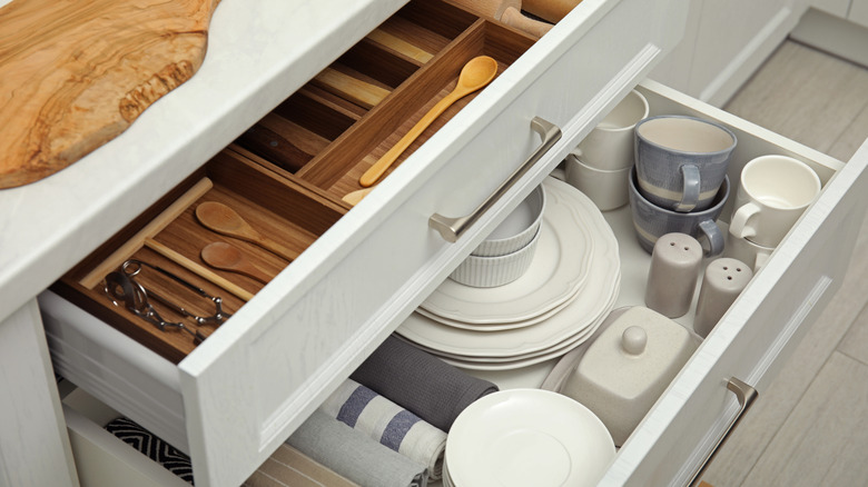Two kitchen drawers organized so that all the cutlery and dishes have a place.