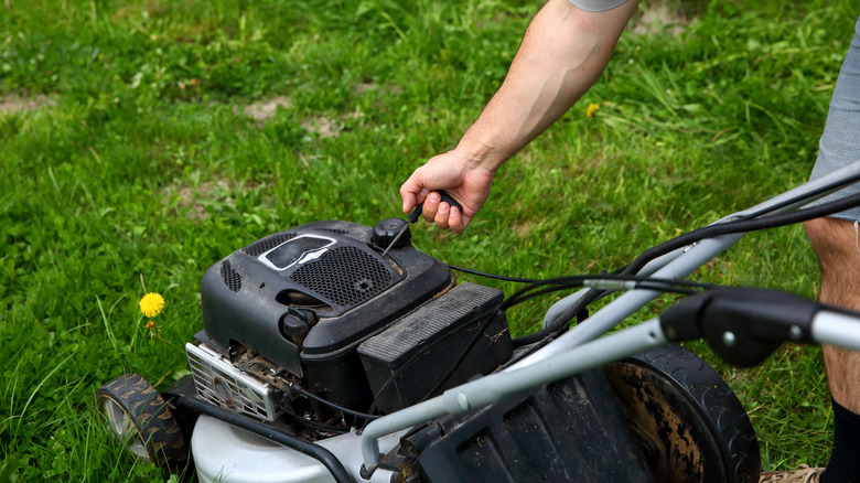 person starting a lawn mower