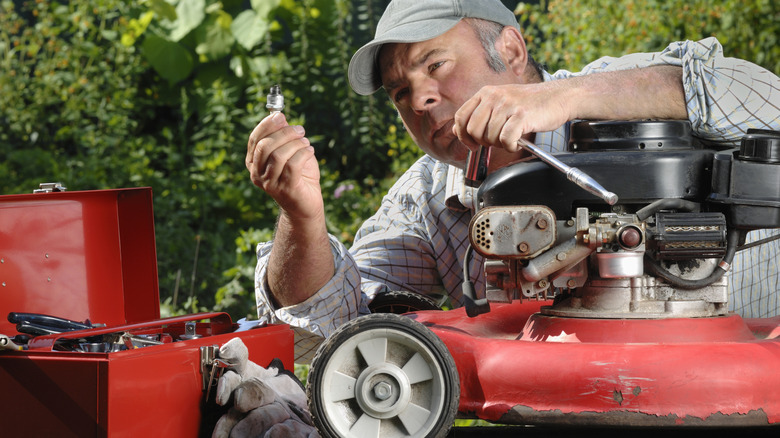 A man fixing a lawn mower