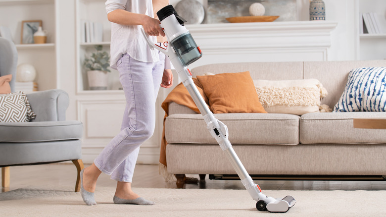 woman vacuuming living room rug