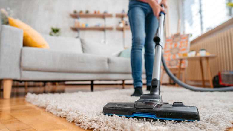 person vacuuming rug