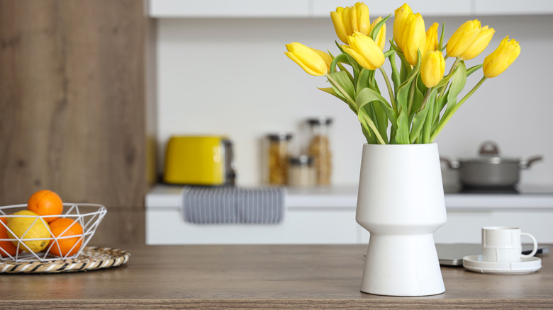 Cooled tone wood countertop and cabinet with yellow tulips, toaster, and citrus