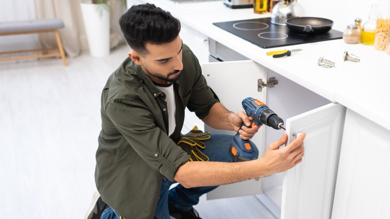 Man installing kitchen cabinet