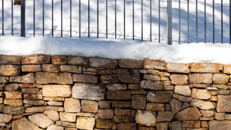Retaining wall and landscape behind it covered in snow