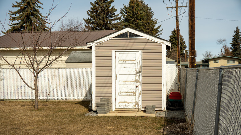 A small portable shed in a house's backyard