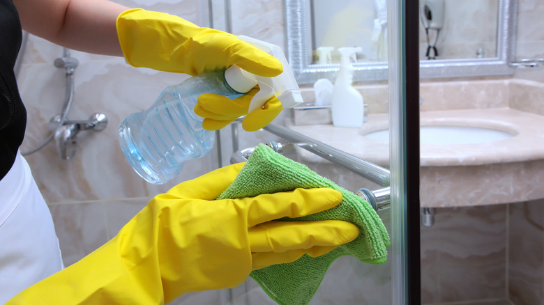 Woman cleaning shower door