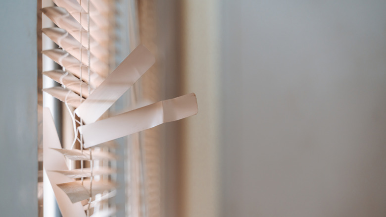 Close up of window blind with damaged and broken slats