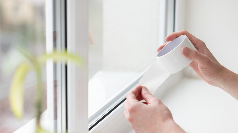 Man using weather sealing tape around a window