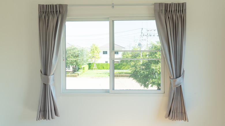 Two gray curtains flanking a small window.
