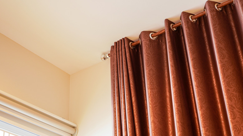 Shiny copper curtains on a wooden rail