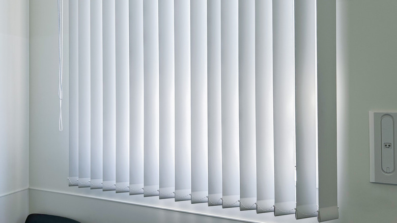 A window with white vertical blinds.