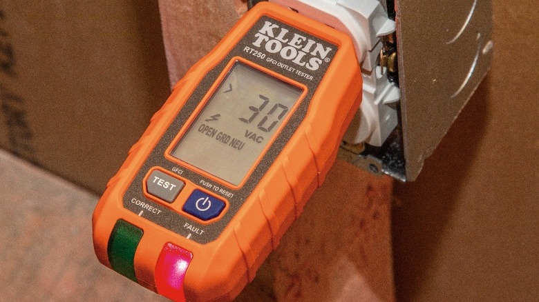 Multimeter plugged into an outlet for testing