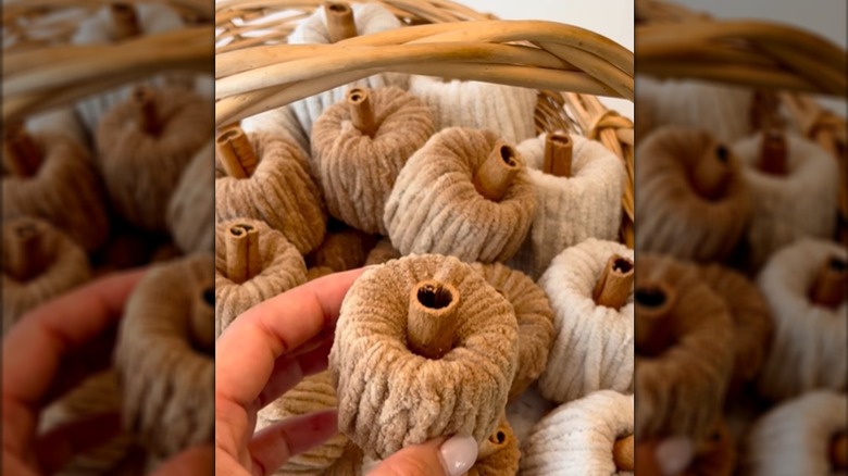 A basket full of yarn pumpkins are made from toilet paper rolls.