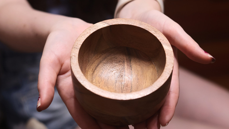 A person holds a bamboo bowl in their hands in a close-up photo
